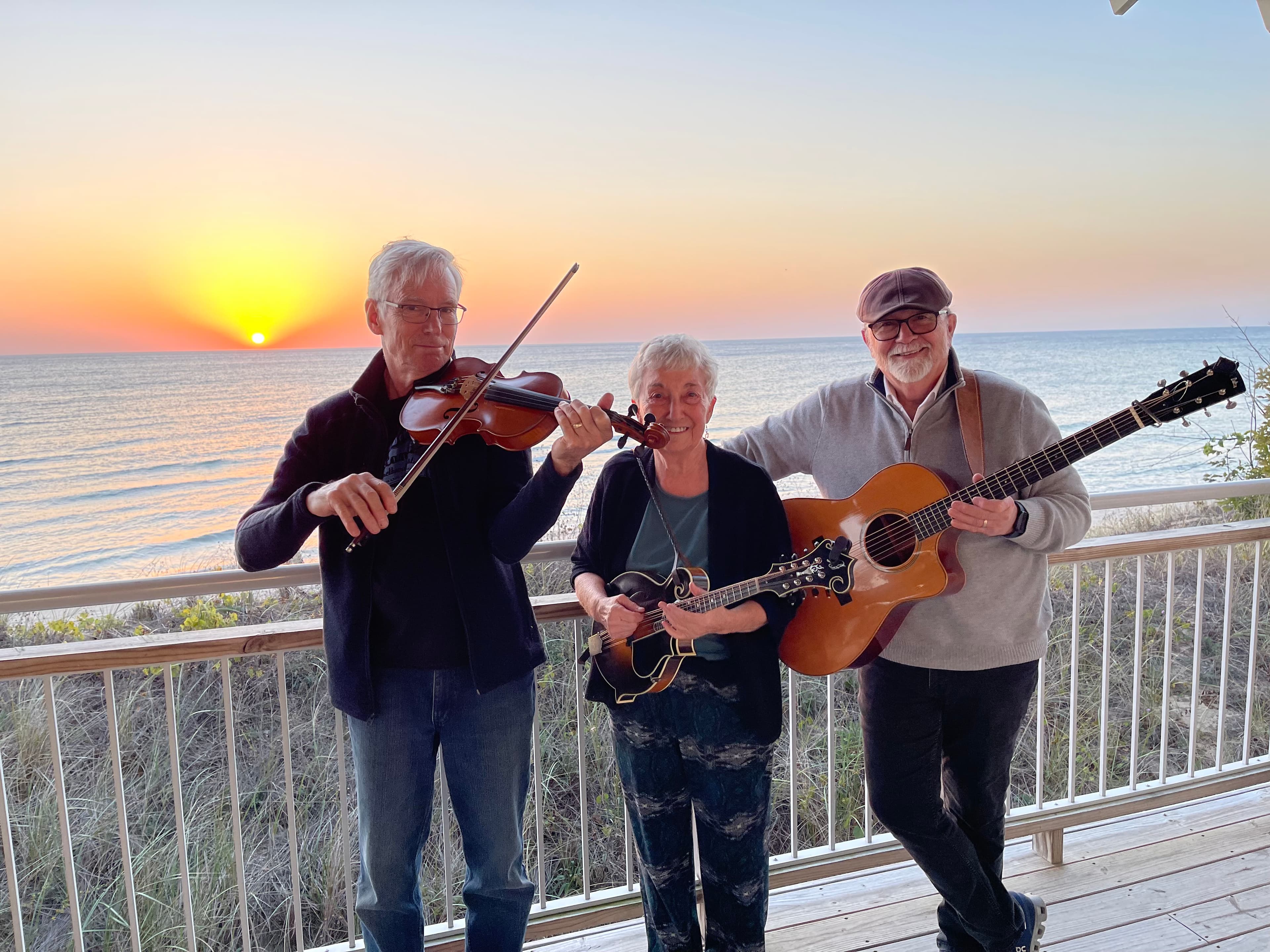 Three band members at sunset with their instruments